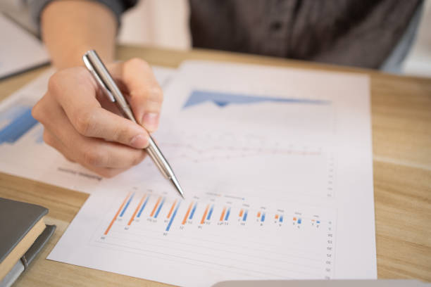 Person analyzing financial charts and graphs representing UAE's leading industries and economic performance.